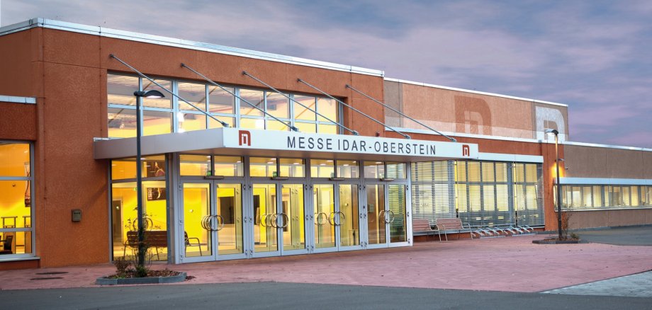 The photo shows an exterior view of the Idar-Oberstein trade fair center.