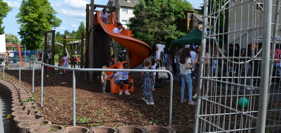 The photo shows children playing on a climbing frame.