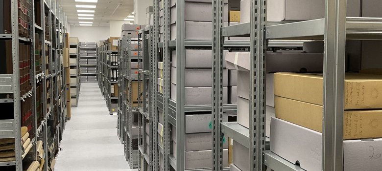 The photo shows one of the stacks with shelves in which the archive material is stored.