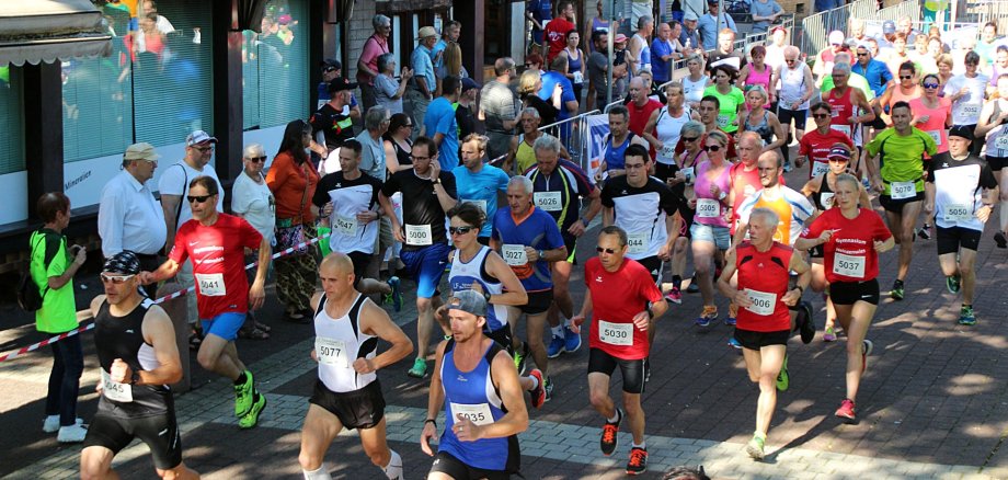 The photo shows a large group of runners on their way through the old town of Oberstein. The route is lined with spectators.