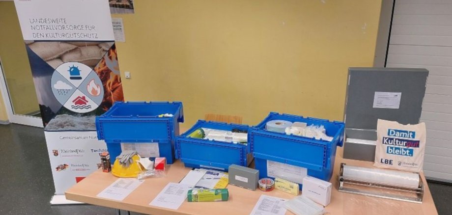 The photo shows a table on which the three boxes of the emergency kit are placed. Their respective contents are spread out in front of the boxes.
