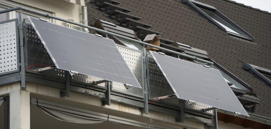 The photo shows two modules of a balcony power plant. They are installed on the railing of a balcony.
