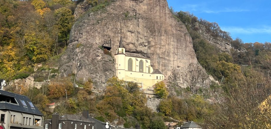 La photo montre l'église du rocher, située à environ 60 mètres au-dessus du fond de la vallée, dans une niche rocheuse.