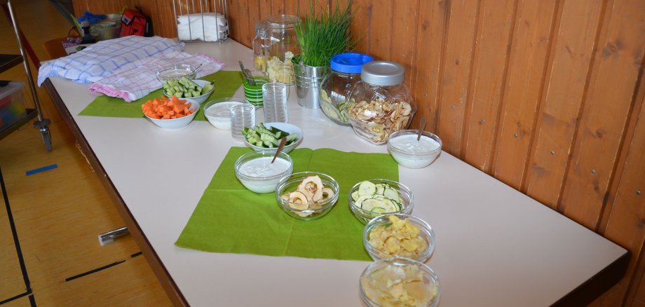 La photo montre une table dressée sur laquelle sont disposés des bols de fruits, de légumes et d'autres céréales.