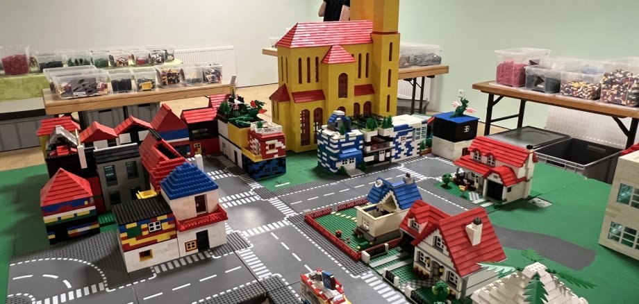 La photo montre les maisons construites avec des briques Lego.