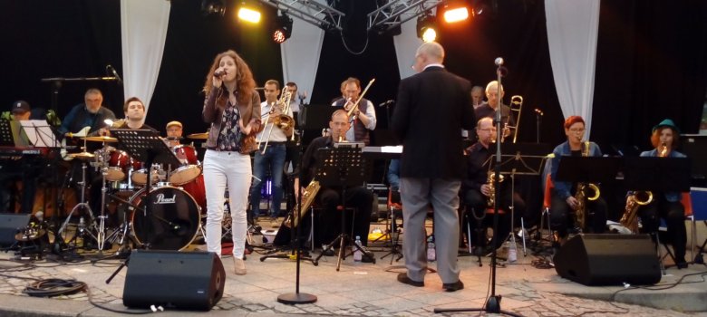La photo montre le groupe avec la chanteuse Julia Oschweski sur la scène de la Schleiferplatz lors des Journées du jazz d'Idar-Oberstein.