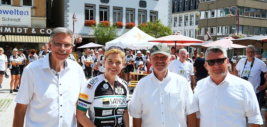 La photo montre de gauche à droite : Bruno Zimmer, directeur de la Fondation Stefan Morsch, Julia Klöckner, membre du Bundestag, Friedrich Marx, maire, et Miroslaw Kowalski, conseiller municipal, sur la place Schleifer.