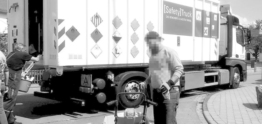 La photo montre un camion qui collecte des polluants avec un employé devant.