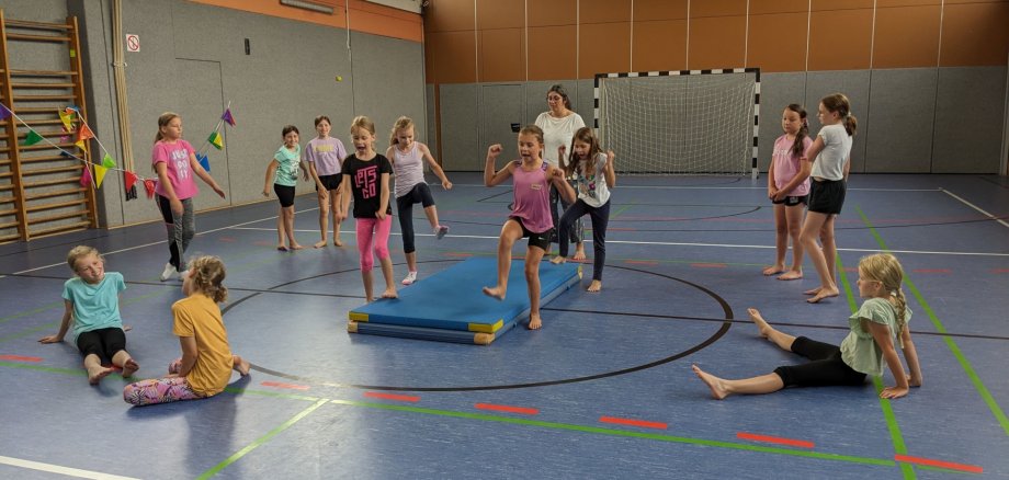 Das Foto zeigt die Mädchen und die Übungsleiterin in einer Sporthalle.