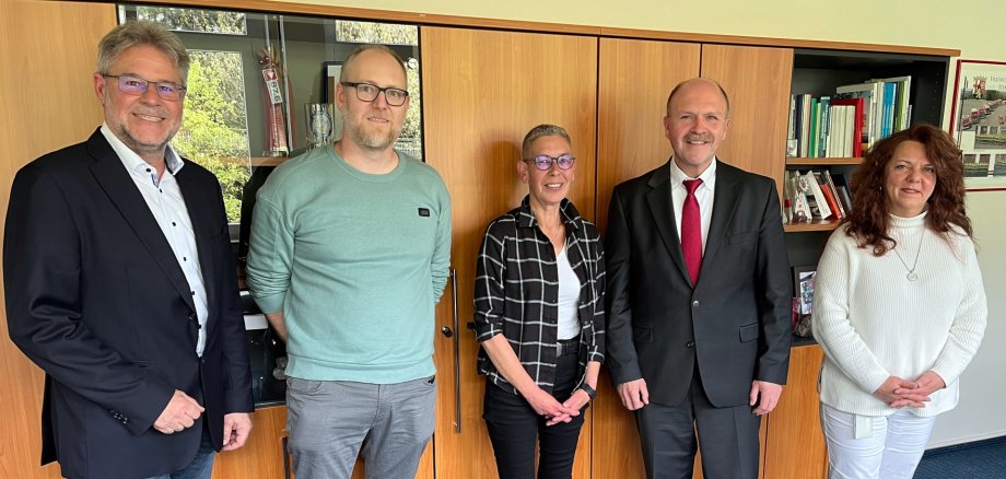 Das Foto zeigt fünf Personen, die im Büro von Bürgermeister Marx nebeneinander vor einer Schrankwand stehen und in die Kamera schauen.