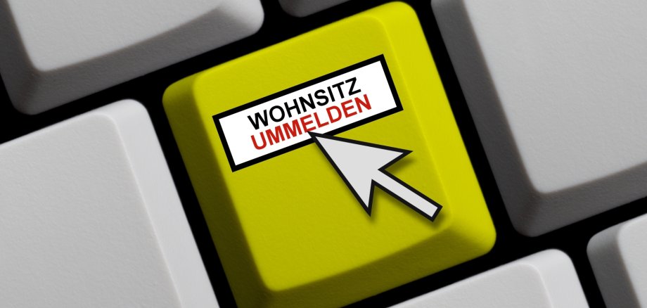 Das Symbolfoto zeigt eine Computertastatur mit  einer grünen Taste mit der Aufschrift "Wohnsitz ummelden".