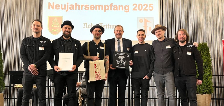 Das Foto zeigt die sechs Musiker zusammen mit OB Frühauf auf der Bühne.